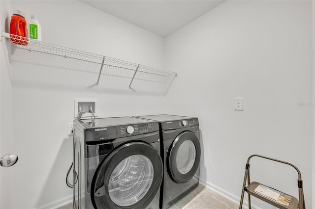 laundry room with light tile patterned flooring and washing machine and dryer