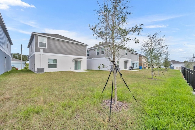 rear view of house with a yard and central air condition unit