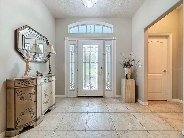 4088 Kingsley St, Clermont, FL 34711 - entryway with light tile patterned floors, baseboards, and a textured ceiling
