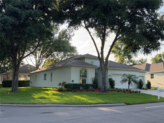 4088 Kingsley St, Clermont, FL 34711 - view of home's exterior featuring a yard, an attached garage, stucco siding, and driveway