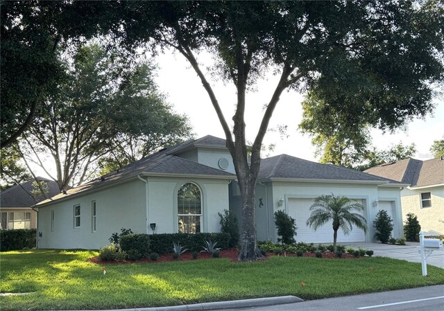 4088 Kingsley St, Clermont, FL 34711 - view of front facade with an attached garage, stucco siding, a shingled roof, a front yard, and driveway