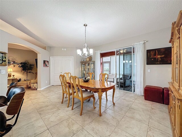 4088 Kingsley St, Clermont, FL 34711 - dining room with light tile patterned floors, a textured ceiling, baseboards, arched walkways, and a chandelier