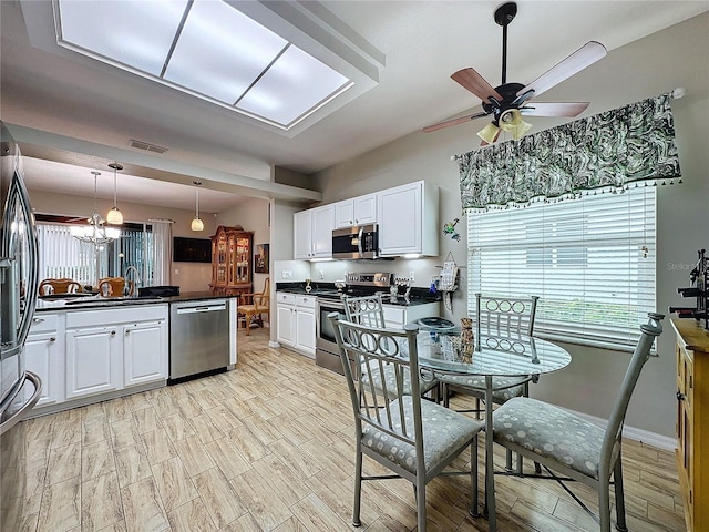 4088 Kingsley St, Clermont, FL 34711 - kitchen with a ceiling fan, dark countertops, stainless steel appliances, white cabinetry, and visible vents