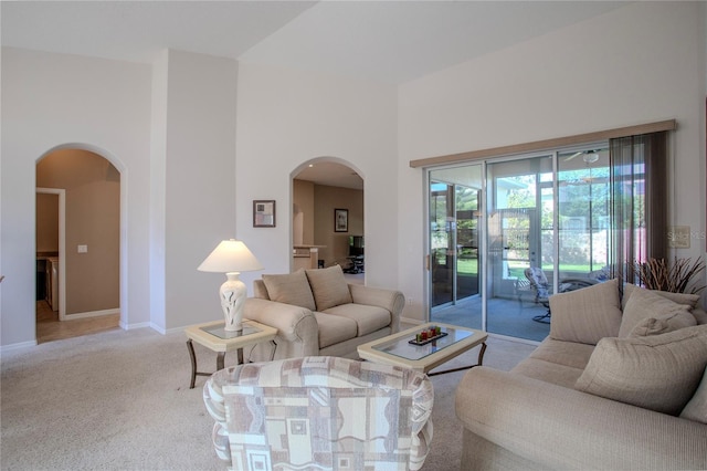 carpeted living room featuring a towering ceiling