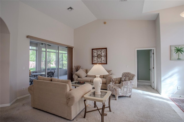 carpeted living room with high vaulted ceiling