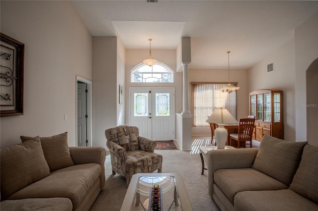 living room with high vaulted ceiling, carpet flooring, and an inviting chandelier