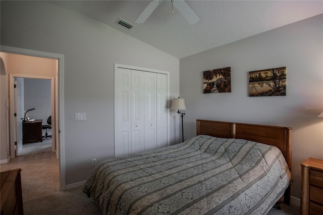 carpeted bedroom with a closet, ceiling fan, a textured ceiling, and vaulted ceiling