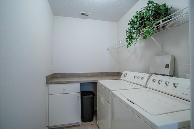 laundry room with a textured ceiling and washer and clothes dryer