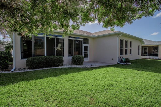 rear view of property with a sunroom and a lawn