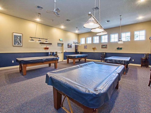 playroom with ceiling fan, a healthy amount of sunlight, a textured ceiling, and pool table