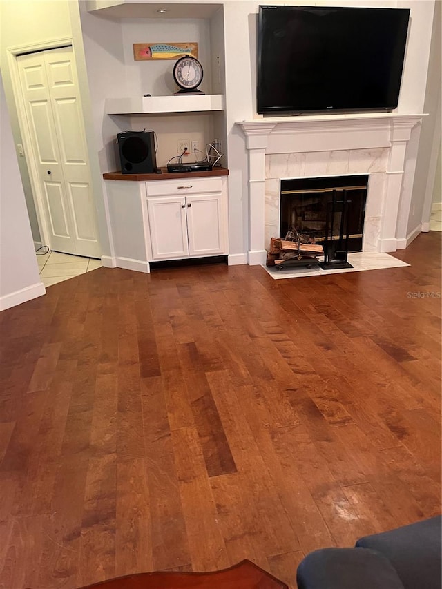 unfurnished living room featuring a tile fireplace and hardwood / wood-style floors