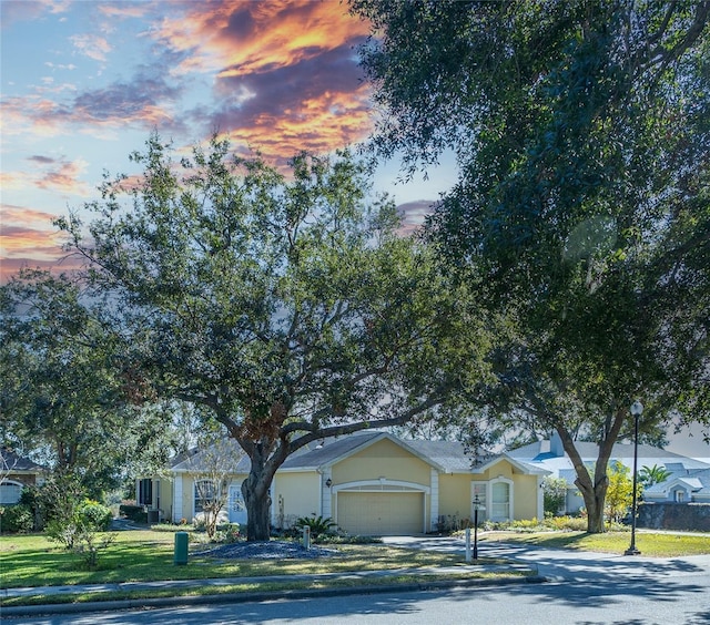 ranch-style home with a garage and a yard