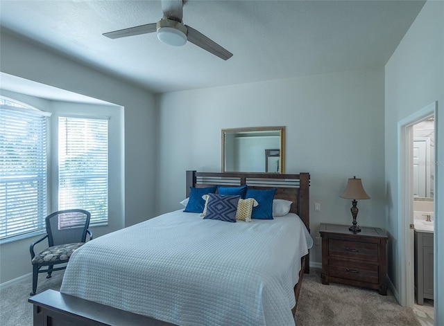 carpeted bedroom featuring ceiling fan and ensuite bath