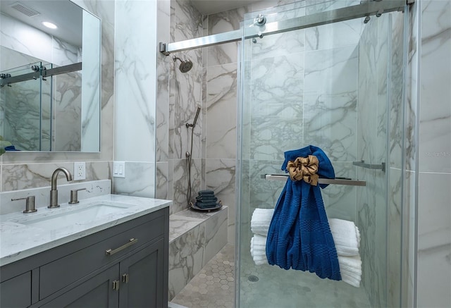 bathroom featuring vanity, an enclosed shower, and tile walls