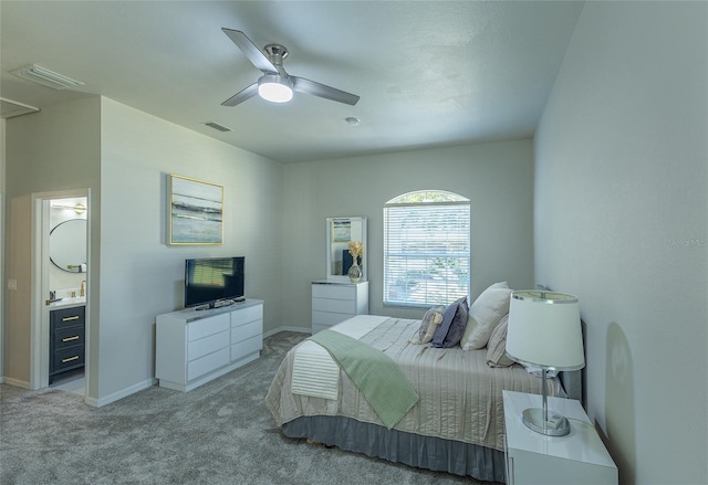 carpeted bedroom with ensuite bath and ceiling fan