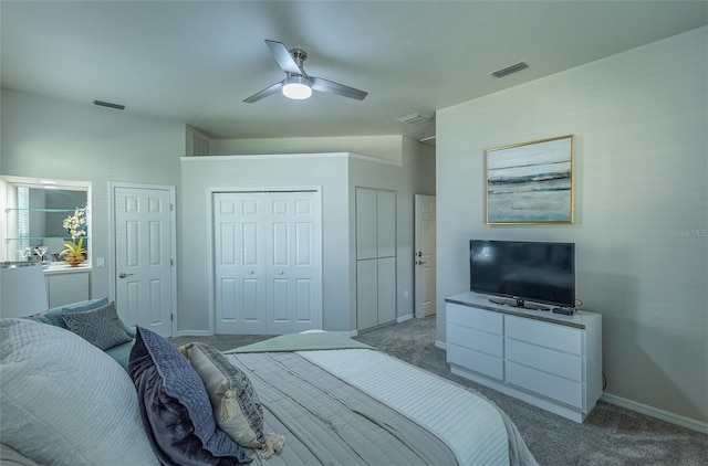 bedroom with carpet, vaulted ceiling, ceiling fan, and multiple closets