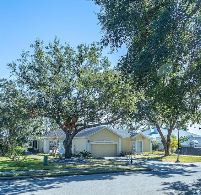 ranch-style home featuring a garage and a front lawn