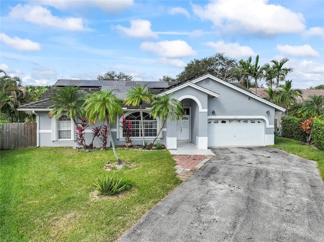 ranch-style house featuring a front yard, solar panels, and a garage