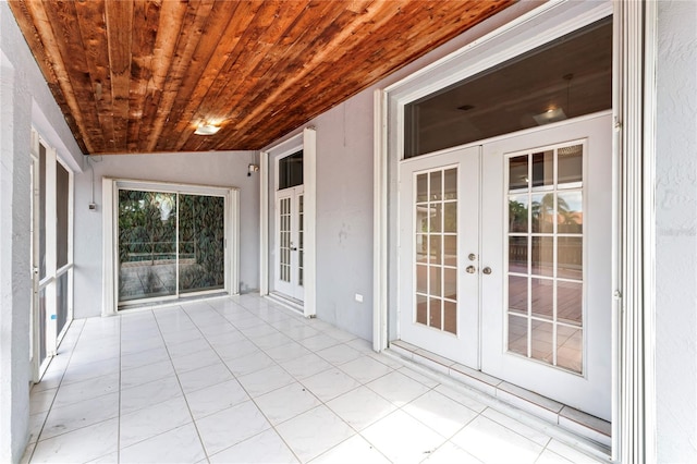 unfurnished sunroom featuring french doors, vaulted ceiling, and wooden ceiling