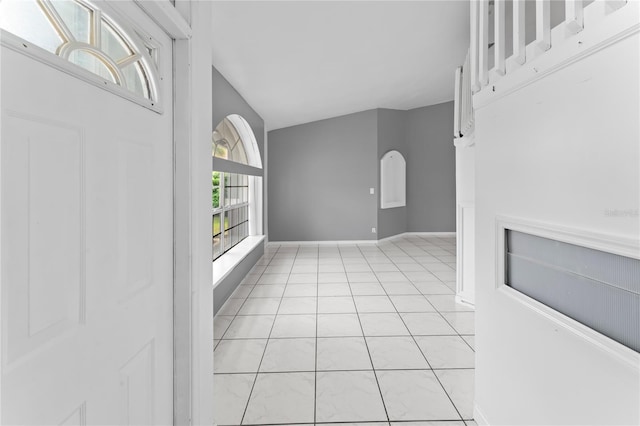 tiled foyer entrance featuring lofted ceiling