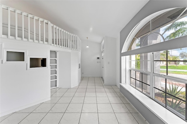 hall featuring vaulted ceiling and light tile patterned floors