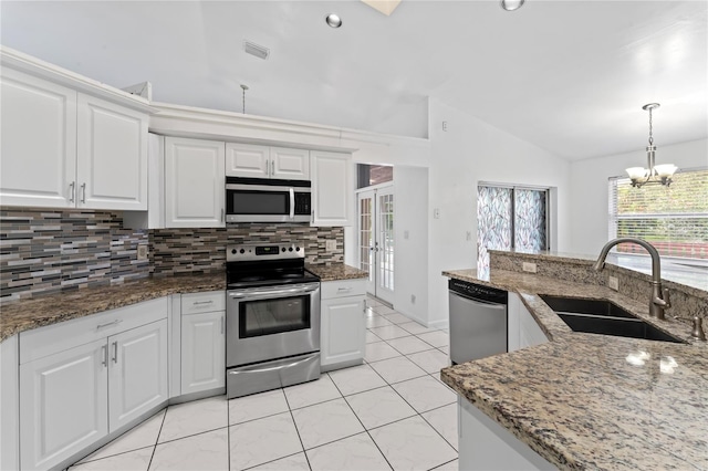 kitchen with vaulted ceiling, stainless steel appliances, sink, and white cabinets