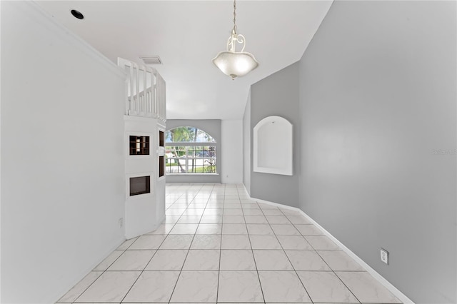 hall featuring lofted ceiling and light tile patterned flooring