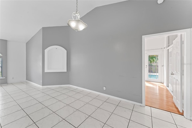 unfurnished room featuring light tile patterned floors and vaulted ceiling