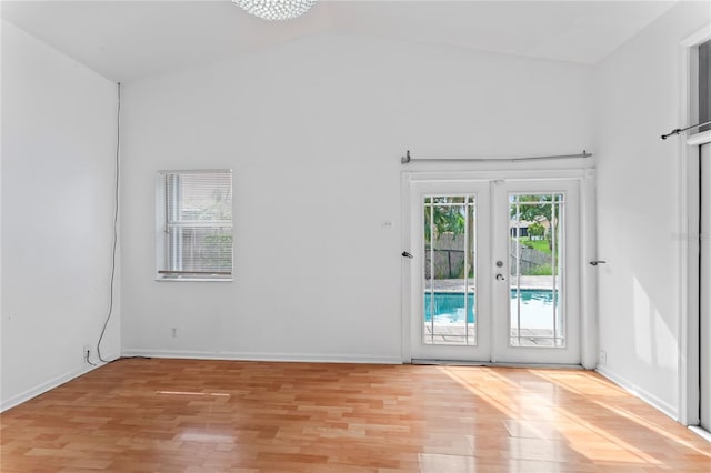 entryway with french doors, light hardwood / wood-style flooring, and high vaulted ceiling