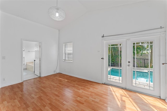 interior space featuring french doors, light hardwood / wood-style floors, and high vaulted ceiling