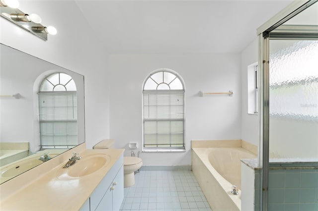 bathroom with plenty of natural light, toilet, a relaxing tiled tub, and tile patterned flooring