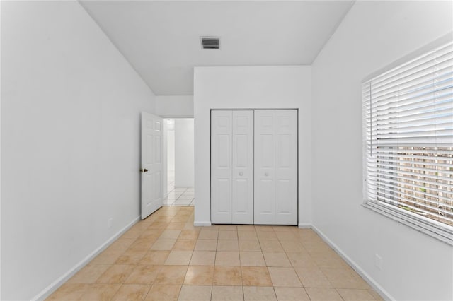 unfurnished bedroom featuring a closet and light tile patterned floors