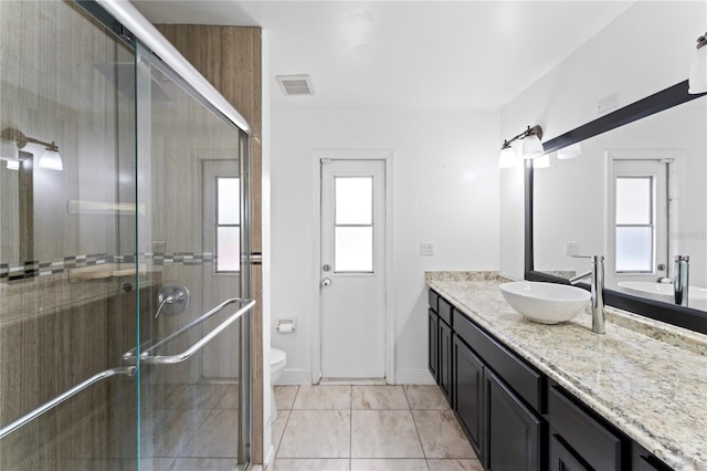 bathroom featuring vanity, toilet, walk in shower, and a wealth of natural light