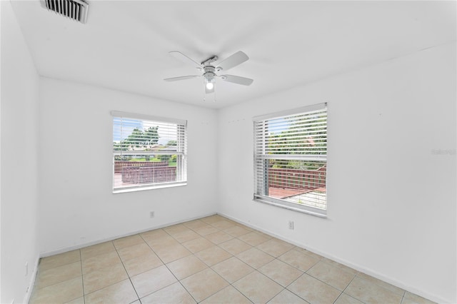 tiled empty room featuring ceiling fan