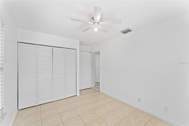 unfurnished bedroom featuring a closet, ceiling fan, and light tile patterned floors