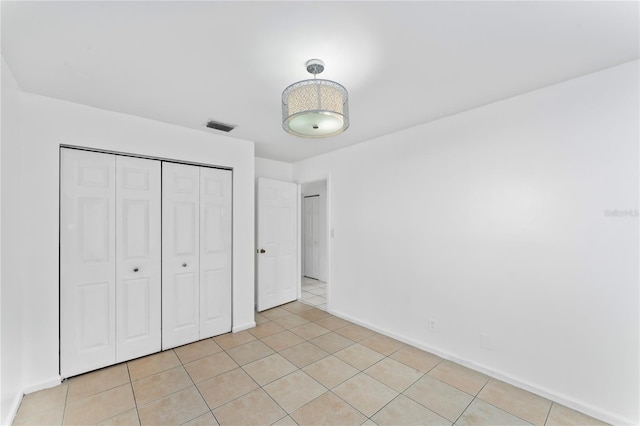 unfurnished bedroom featuring a closet and light tile patterned floors