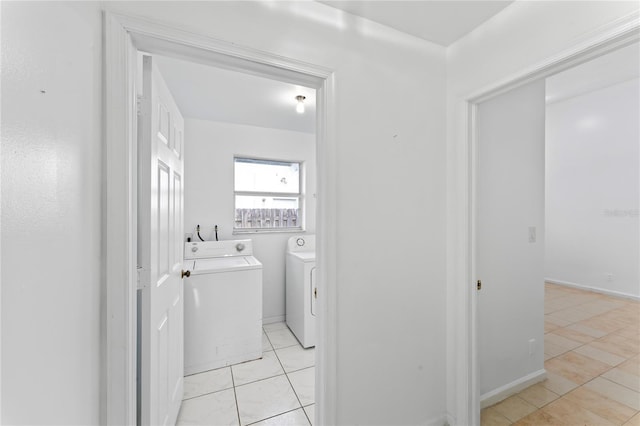 washroom featuring light tile patterned floors and washer and clothes dryer