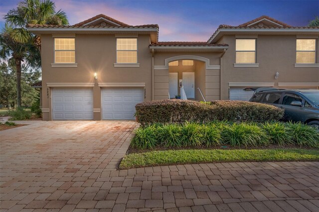 5279 Bowline Ct, Oxford, FL 34484 - view of front of home with an attached garage, driveway, a tile roof, and stucco siding
