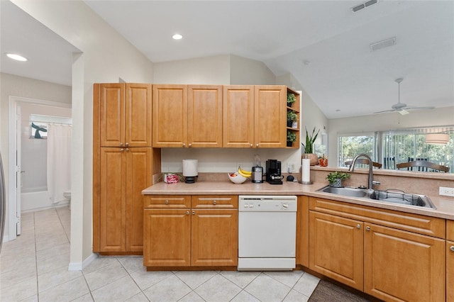 kitchen featuring sink, light tile patterned floors, lofted ceiling, and dishwasher