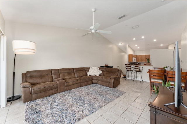 living room featuring lofted ceiling, light tile patterned floors, and ceiling fan