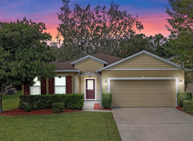 ranch-style house with a yard and a garage