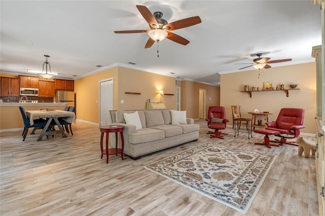 living room with light hardwood / wood-style flooring, ceiling fan, and crown molding