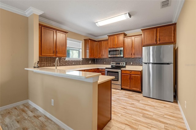 kitchen with kitchen peninsula, decorative backsplash, stainless steel appliances, and light wood-type flooring