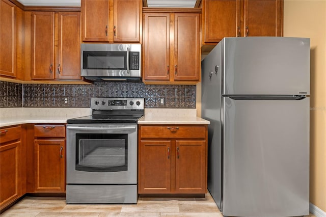 kitchen with light hardwood / wood-style floors, stainless steel appliances, and tasteful backsplash