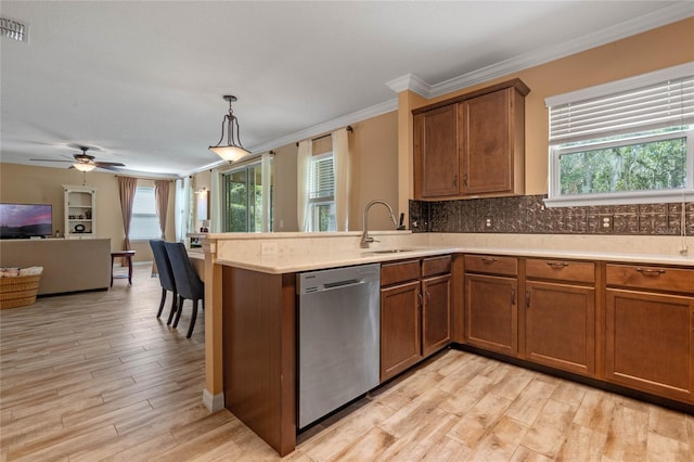 kitchen featuring stainless steel dishwasher, sink, light wood-type flooring, and a wealth of natural light