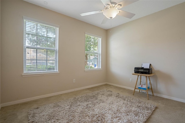 carpeted spare room featuring ceiling fan