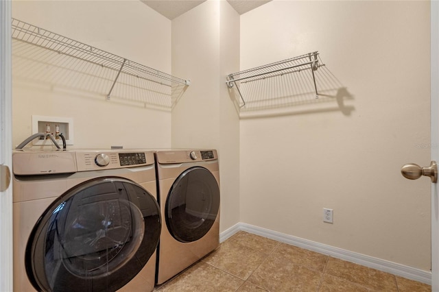 washroom featuring washing machine and clothes dryer and light tile patterned floors