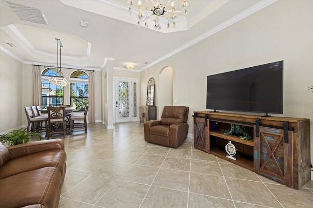 living room with crown molding, light tile patterned flooring, a tray ceiling, and a chandelier