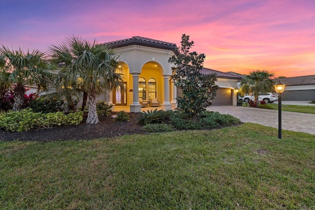 mediterranean / spanish house featuring a yard and a garage