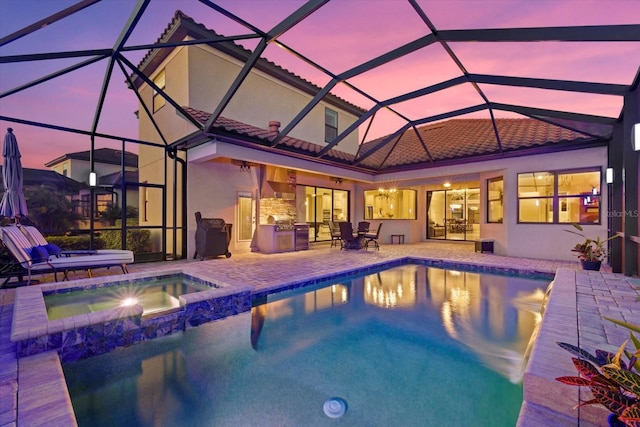 pool at dusk featuring an in ground hot tub, ceiling fan, a patio area, and a lanai